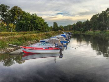 Boat moored on lake against sky