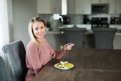 Portrait of a smiling young woman holding food