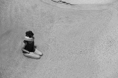 High angle view of woman sitting at ocean beach