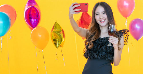 Portrait of a smiling young woman with balloons