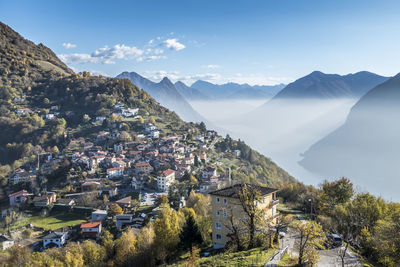 Aerial view of townscape by mountain against sky