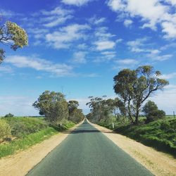 Road amidst trees against sky