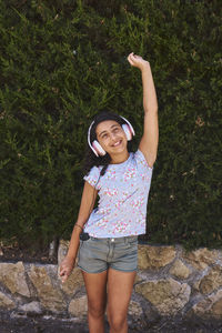 A little girl jumping for joy listening to music with headphones. girl concept