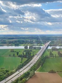 High angle view of road amidst field against sky