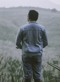 Rear view of man looking at camera. 