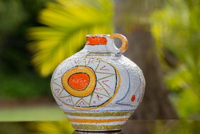 Close-up of creative urn against tree at park