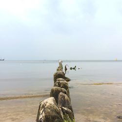 Scenic view of rocks on beach against sky