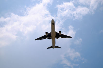 Low angle view of airplane flying against sky