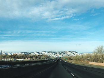 Road by mountain against sky