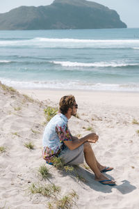 Young man sitting at the beach