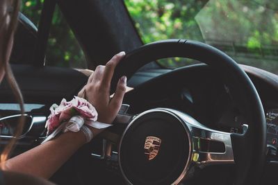 Midsection of woman holding camera in car