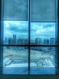 View of cityscape against cloudy sky
