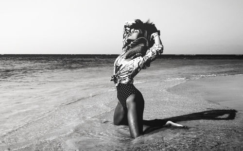 Young woman kneeling on beach