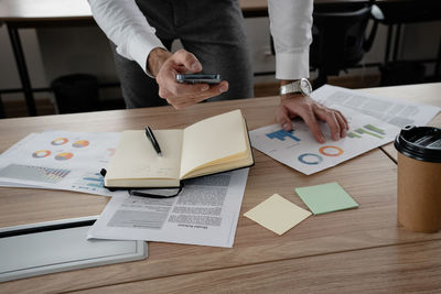 Midsection of businessman working on table