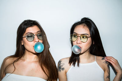 Portrait of young women blowing bubble gum