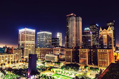 Illuminated cityscape against sky at night