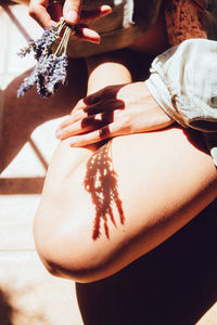 Midsection of woman holding flowers