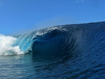 Scenic view of sea waves against clear blue sky