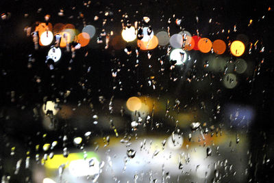 Raindrops on glass window at night