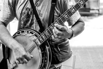 Midsection of man playing guitar