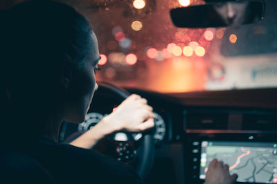 Rear view of woman watching map while driving car