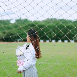 Close-up of bird perching on chainlink fence