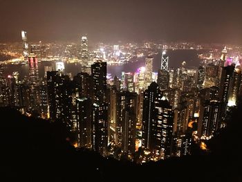 Illuminated cityscape against sky at night