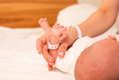 Cropped hand of woman holding baby hand