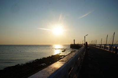 Pier on sea at sunset