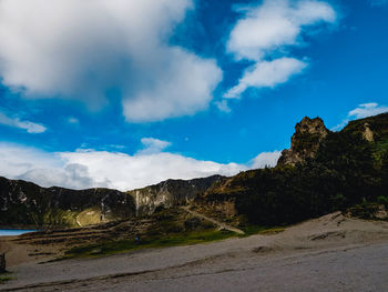 Scenic view of road by mountains against sky