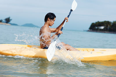 Portrait of woman kayaking in sea