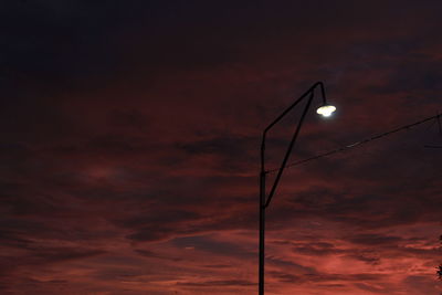 Low angle view of illuminated street light against sky at sunset