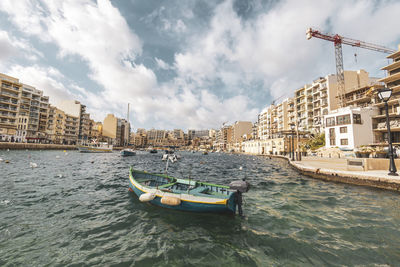 Boats in sea against cloudy sky