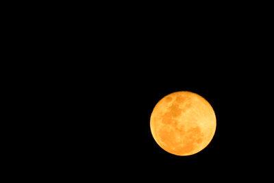 Low angle view of full moon against clear sky at night