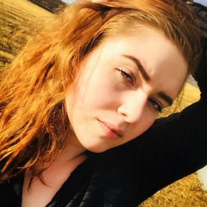 Close-up portrait of beautiful young woman standing on field