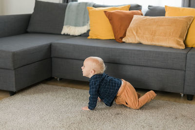 Rear view of boy sitting on sofa at home