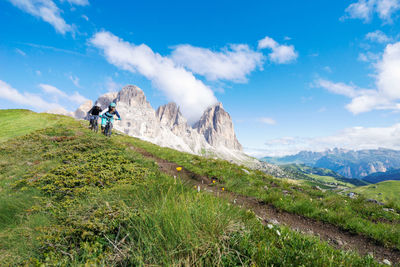 Low angle view of people riding bicycles on mountain