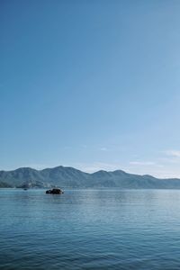 Scenic view of lake against clear blue sky