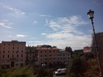Buildings in city against cloudy sky