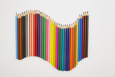 Close-up of multi colored pencils against white background