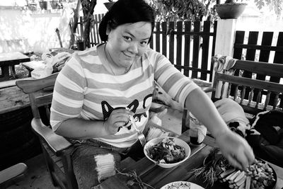 Portrait of woman eating food while sitting at restaurant