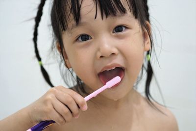 Close-up portrait of cute girl holding camera