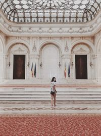 Full length portrait of woman walking in palace