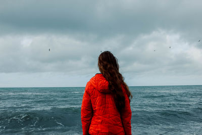 Rear view of woman looking at sea against sky