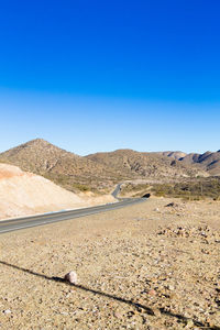 Scenic view of desert against clear blue sky