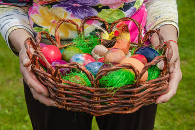 Midsection of woman holding colorful basket