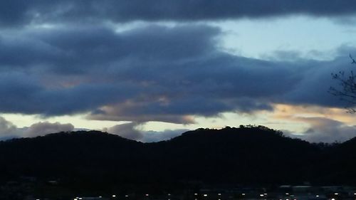 Silhouette of mountain against cloudy sky