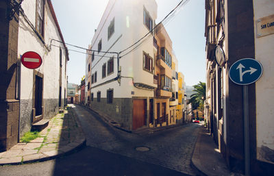 Road amidst buildings against sky