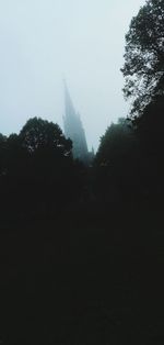 Low angle view of silhouette trees against sky