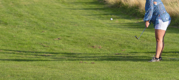 Woman playing golf on grass